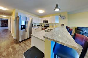 a kitchen with a counter and a refrigerator at Put-in-Bay Waterfront Condo #109 in Put-in-Bay