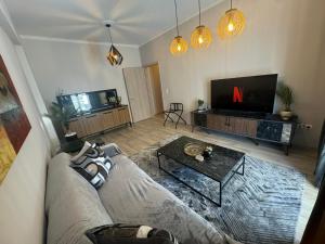 a living room with a couch and a tv at Supreme Golden Suite in Alexandroupoli