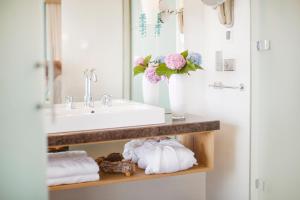 a bathroom with a sink and a counter with towels at Sun Gardens Dubrovnik in Dubrovnik