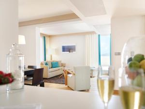 a living room with a table with a glass of wine at Sun Gardens Dubrovnik in Dubrovnik