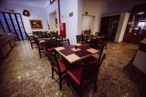 a dining room with wooden tables and chairs at Hotel Euro Suite Poços de Caldas By Nacional Inn in Poços de Caldas