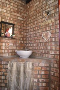 a bathroom with a sink in a brick wall at Orpheus Inn Camping in Kaneb Pos