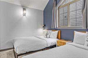 two beds in a room with blue walls and a window at Mystic Chalet- Views, Pool, Hot Tub, Pets - managed by Little Sister Getaways in Canmore +34 photos