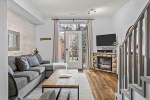 a living room with a couch and a fireplace at Mystic Chalet- Views, Pool, Hot Tub, Pets - managed by Little Sister Getaways in Canmore