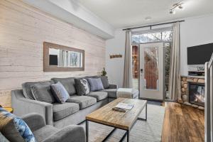a living room with a couch and a table at Mystic Chalet- Views, Pool, Hot Tub, Pets - managed by Little Sister Getaways in Canmore