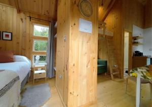 a bedroom with a bed and a wooden wall at Cabañas Refugio Río Roberto in Villa Santa Lucía