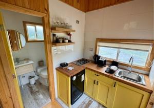 a small kitchen with a sink and a toilet at Cabañas Refugio Río Roberto in Villa Santa Lucía +2 photos