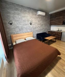 een slaapkamer met een groot bed en een keuken bij Апартаменти в Гранях in Dnipro