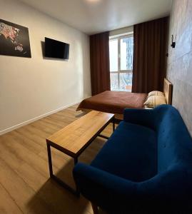 een woonkamer met een blauwe bank en een tafel bij Апартаменти в Гранях in Dnipro