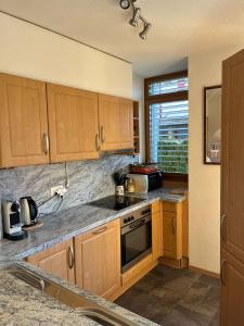 a kitchen with wooden cabinets and a stove top oven at Appartement 01 Résidence Le Grand Combin à Champex in Champex +12 photos
