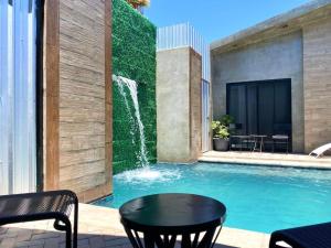 a swimming pool with a table and a waterfall at Antía Valle de Guadalupe in Ensenada