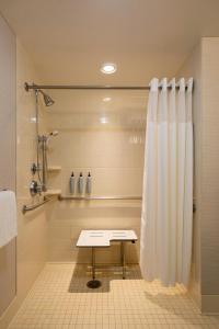 a bathroom with a shower and a table in it at Courtyard by Marriott Madison West / Middleton in Middleton