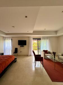 a bedroom with a bed and a tv and a couch at Mazagan private villa in El Jadida