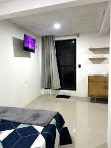 a bedroom with a bed and a tv on the wall at Casa Magdalena N1 in San Pedro La Laguna
