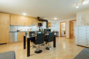 a kitchen with a table and chairs in a room at Apartment Bergzauber in Amden