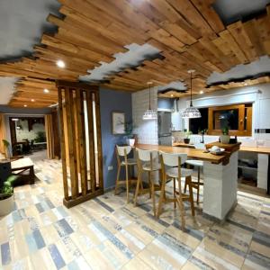 a kitchen with a wooden ceiling and a wooden table and chairs at Talita Cumi in Villa Santa Cruz del Lago
