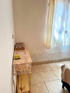 Zimmer mit einem Holztisch und einem Fenster in der Unterkunft Cabaña La escondida I in Purmamarca