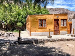 a small wooden cabin in front of a mountain at Cabaña La escondida I in Purmamarca +13 photos
