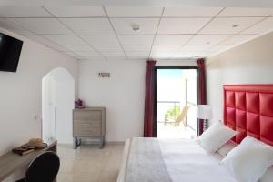 Un dormitorio con una cama grande con cabecero rojo. en Les Roches Blanches, en Porto Vecchio