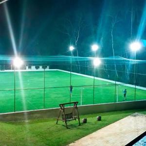 einen Stuhl, der nachts auf einem Tennisplatz sitzt in der Unterkunft Sitio Recanto Feliz na Estrada do Vinho km 4,5 - Sao Roque in São Roque