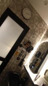 a bathroom mirror with a clock and a sink at best rest apartments - 3 in Riyadh +15 photos