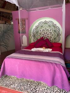トロンコネスにあるCasa Luciernagaのベッドルーム1室(紫色のベッド1台、花付)