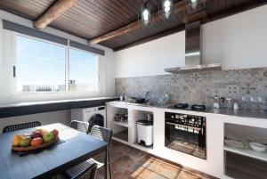 una cucina con un tavolo con una ciotola di frutta sopra di Apartment Geranio - Rural Guest Apartment a Tías Altre 24 foto