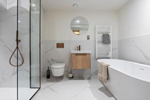 ein Badezimmer mit Badewanne, Toilette und Waschbecken in der Unterkunft Leeds Centre Modern Luxury Duplex 2-bedroom apartment in Central Station + 37 Fotos