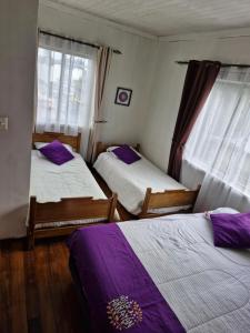 Kama o mga kama sa kuwarto sa Hostal Arrayan