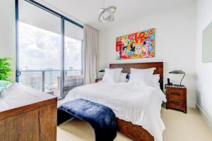 een slaapkamer met een groot bed en een groot raam bij Magic Miami Penthouse, Ocean & City Views, Pool, Spa, Gym, in Miami