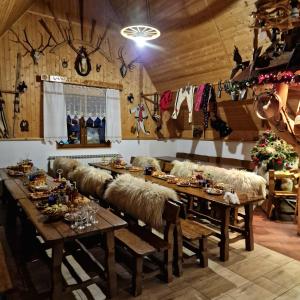 a dining room with a long table with hay seats at Willa Florynka in Biały Dunajec