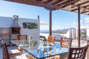 a dining room with a glass table and chairs at Apartment Orquidia - Rural Guest Apartment in Tías
