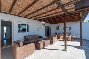 an outdoor patio with couches and a wooden pergola at Apartment Orquidia - Rural Guest Apartment in Tías