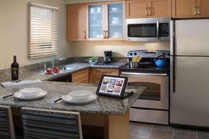 a kitchen with a tablet on a granite counter top at Sonesta ES Suites Cincinnati - Blue Ash in Blue Ash