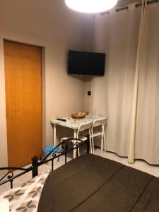 una stanza con un tavolo e una TV su una parete di Il Greco a Catania