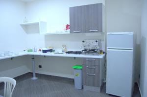 a kitchen with a desk and a white refrigerator at Civico 83 in Reggio di Calabria