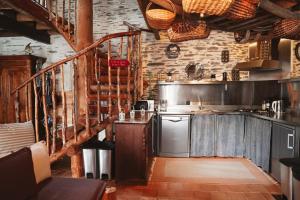 a kitchen with a stove and a staircase at L'Hôt'Berge in La Chapelle-de-Brain