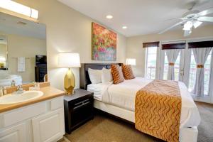 a bedroom with a bed and a sink and a mirror at Grand Crowne Resort in Branson