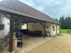 a pavilion with a table and chairs in front of a house at Penzion Emilka in Jindrichuv Hradec