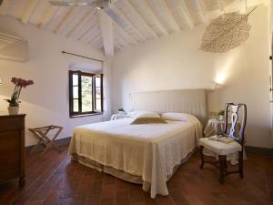 a bedroom with a large white bed and a chair at Villa Serena in Marcialla +32 photos