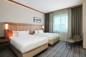 a hotel room with two beds and a window at Courtyard by Marriott Warsaw Airport in Warsaw