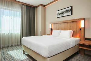 a bedroom with a large bed and a large window at Courtyard by Marriott Warsaw Airport in Warsaw