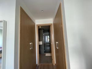 pasillo con 2 puertas de madera y espejo en Charmant studio avec vue sur mer, en Rabat
