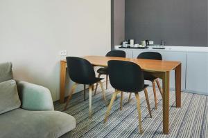 a dining room table with four chairs and a couch at Courtyard by Marriott Warsaw Airport in Warsaw