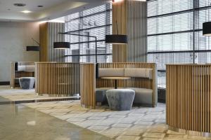 a lobby with a table and chairs and windows at Courtyard by Marriott Warsaw Airport in Warsaw