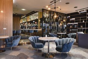 a restaurant with blue chairs and tables and a bar at Courtyard by Marriott Warsaw Airport in Warsaw