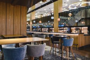 a restaurant with tables and chairs and a bar at Courtyard by Marriott Warsaw Airport in Warsaw