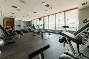 a gym with treadmills and machines in a room at Courtyard by Marriott Warsaw Airport in Warsaw