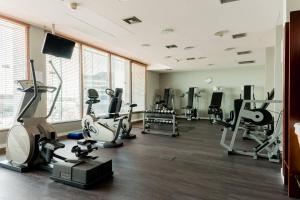 a gym with several treadmills and machines in a room at Courtyard by Marriott Warsaw Airport in Warsaw