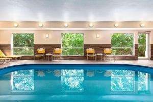 a house with a swimming pool with chairs and windows at SureStay by Best Western Mount Pleasant Racine in Mount Pleasant